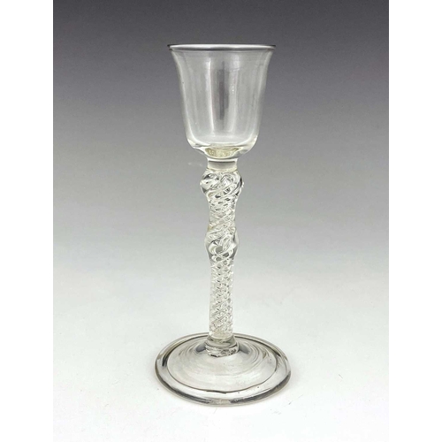 519 - A double knopped air twist wine glass, the bell shaped bowl on a double series helical stem with cen... 