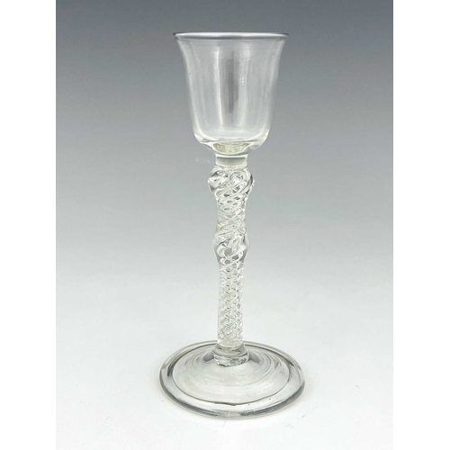 519 - A double knopped air twist wine glass, the bell shaped bowl on a double series helical stem with cen... 