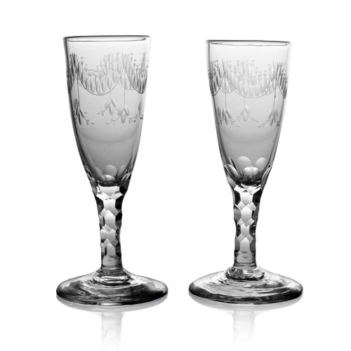 523 - A pair of 18th century glass Champagne flutes, circa 1790, the round funnel bowls engraved with Neoc... 