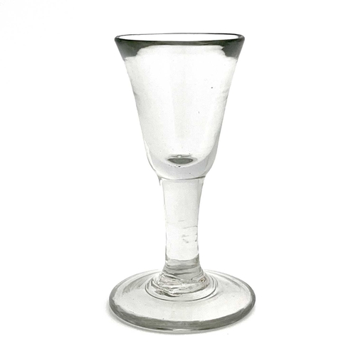 524 - A plain stemmed toasting glass, circa 1740, the heavy bell shaped bowl on a short stem and thick foo... 