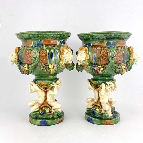 684 - A pair of majolica glazed jardinieres, lion mask and garlands to the frieze, integral triple figural... 