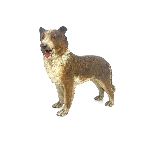 696 - A cold painted pottery figure of a dog, in the Goldscheider style, realistically modelled and set wi... 