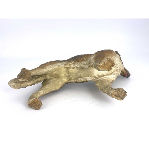 696 - A cold painted pottery figure of a dog, in the Goldscheider style, realistically modelled and set wi... 