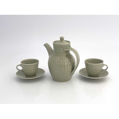 747 - Harry Davis for Crowan Pottery, a studio porcelain coffee pot and two cups and saucers, celadon glaz... 