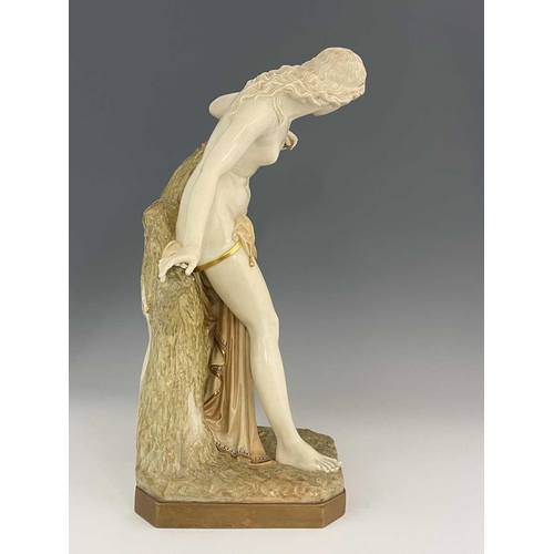 780 - A Royal Worcester figure 'The Bather', circa 1903 modelled as a semi robed maiden afore a tree stump... 