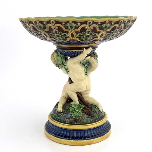 792 - A Minton majolica figural comport, 1863, modelled as two Bacchanalian putti on a vine moulded domed ... 