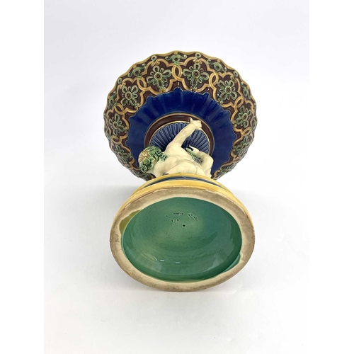 792 - A Minton majolica figural comport, 1863, modelled as two Bacchanalian putti on a vine moulded domed ... 