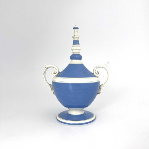 832 - A pearlware twin handled money box, circa 1800, pedestal urn form glazed in blue and white, with bob... 