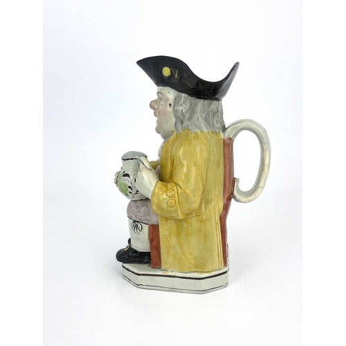 851 - A Staffordshire Toby jug, modelled with a frothing jug, lilac breeches, yellow coat and striped wais... 