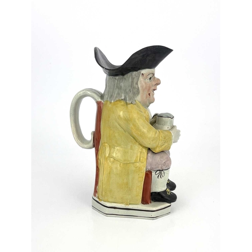 851 - A Staffordshire Toby jug, modelled with a frothing jug, lilac breeches, yellow coat and striped wais... 