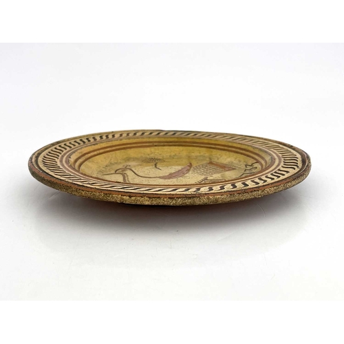 854 - A slipware dish, sgraffitto decorator with an image of a peacock and dated 1733, possibly Devon or S... 