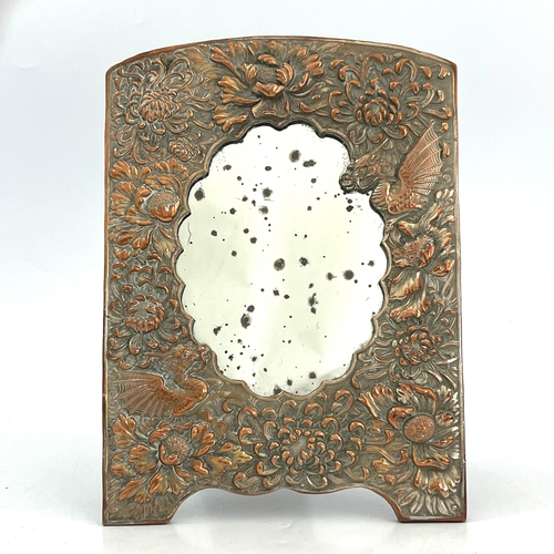 490A - A Japanese embossed copper and silver plated easel mirror, cast in relief with chrysanthemums and dr... 