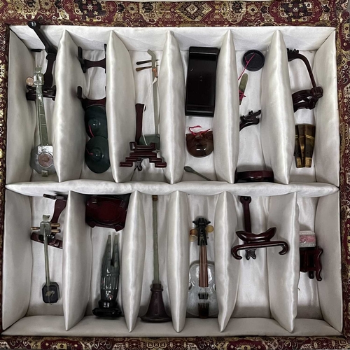 47 - A collection of Chinese carved hardstone and jadeite miniature musical instruments, cased