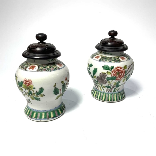 157 - A pair of Chinese famille vert vases and covers, baluster form, in Kangxi style, decorated with flow... 