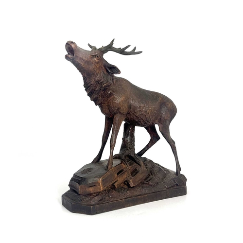 167 - A Black Forest carved wooden model of a stag, standing on a rocky outcrop with head raised, five-poi... 