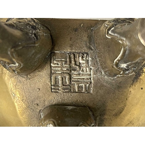 212 - An Oriental bronze censer, modelled in relief with a figure on a dragon to each side, the lid with G... 