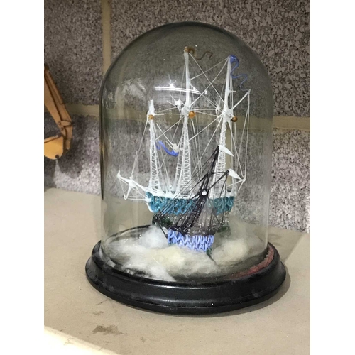 214 - A Victorian lampwork model of tall ships under a glass dome on ebonised socle base, 24cm high