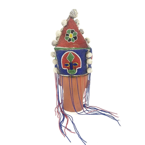 219 - An African tribal beaded headdress, pyramidal form with bobbles and tassels, 30cm high