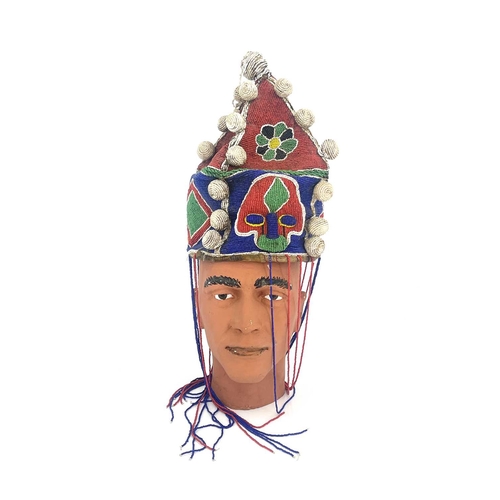 219 - An African tribal beaded headdress, pyramidal form with bobbles and tassels, 30cm high