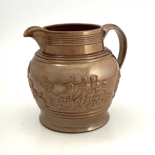 317 - A large brown glazed jug, circa 1820, relief moulded with rural hunting scene. 23 cm tall.