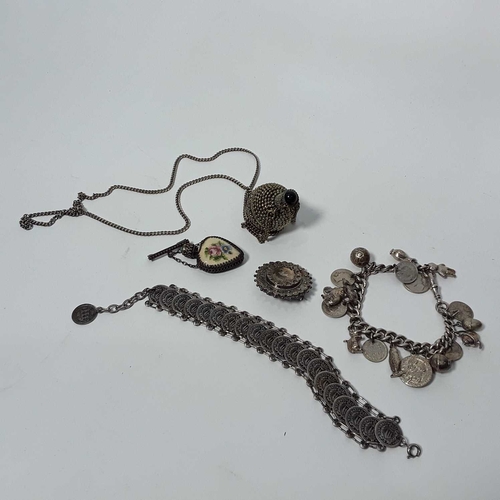 521 - A silver charm bracelet, a coin bracelet, a silver mourning brooch, and two white metal scent mounte... 