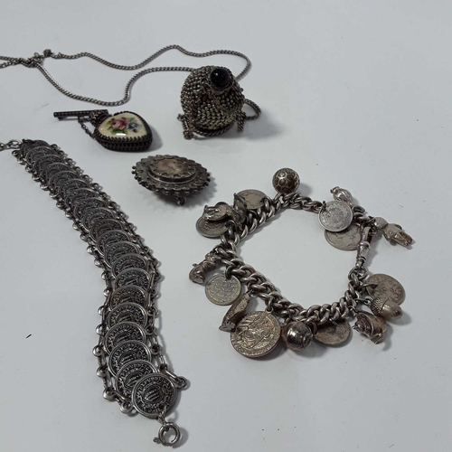 521 - A silver charm bracelet, a coin bracelet, a silver mourning brooch, and two white metal scent mounte... 