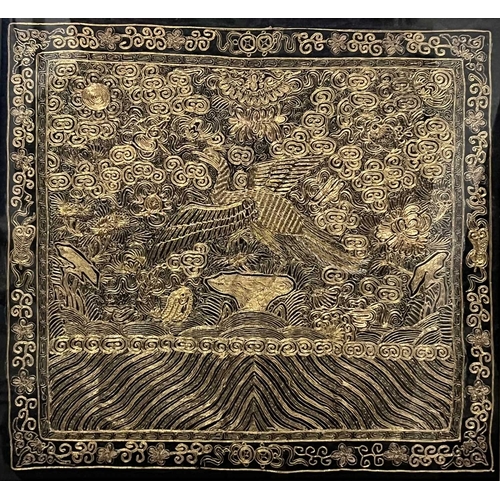 587 - A Chinese gold bullion work panel, depicting an exotic bird amongst foliage, black silk ground, 29 b... 