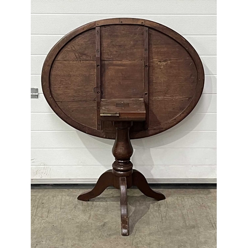 667 - An oval tilt top table, on tripod supports. W: 97 cm D: 72 cm H: 68 cm