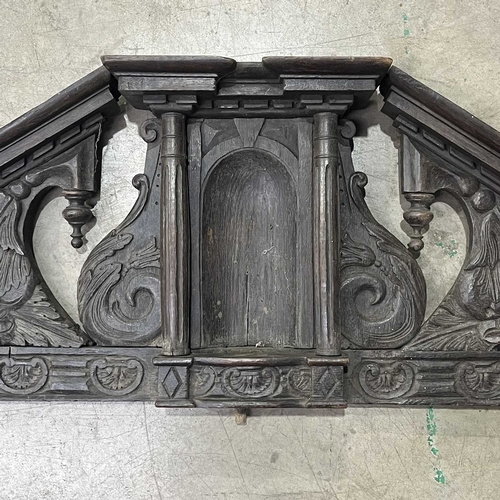 673 - An antique carved oak country house internal door pediment, scroll carved incorporating a central ni... 