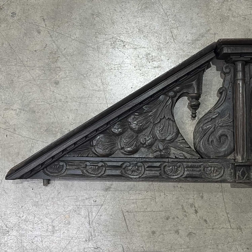 673 - An antique carved oak country house internal door pediment, scroll carved incorporating a central ni... 