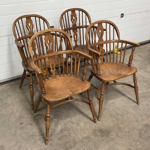 706 - A set of four reproduction Windsor armchairs, with bent wood top-rail and arm rests, linked by a pie... 