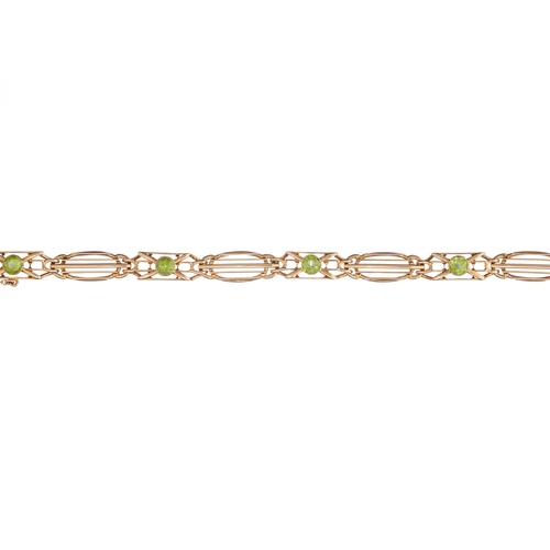 105 - An Art Nouveau 15ct gold peridot openwork bracelet, stamped 15ct, length 18.5cm, 16.6g