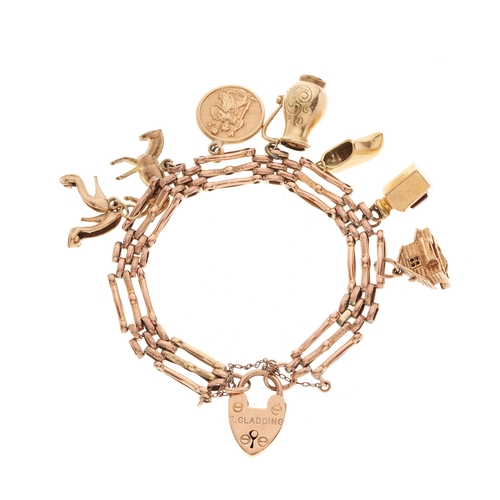 95 - A mid 20th century 9ct gold gate bracelet, suspending various charms, bracelet stamped 9ct, some cha... 