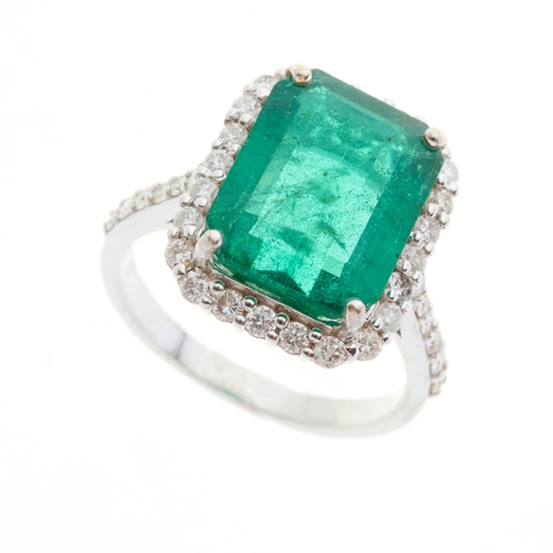 163 - An 18ct gold emerald and brilliant-cut diamond cluster ring, with similarly-cut diamond line shoulde... 