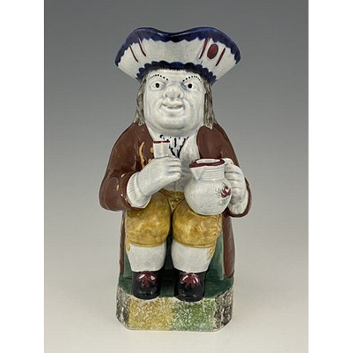 1001 - A Mexborough Toby jug, modelled holding a jug and a beaker, caryatid figural handle, sponge decorate... 