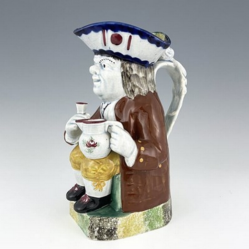 1001 - A Mexborough Toby jug, modelled holding a jug and a beaker, caryatid figural handle, sponge decorate... 