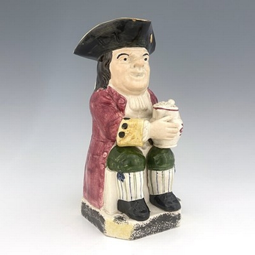 1002 - A Yorkshire Toby jug, circa 1800, modelled holding a frothing jug, pink coat and green breeches, 26.... 