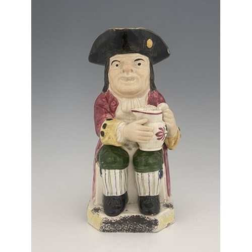 1002 - A Yorkshire Toby jug, circa 1800, modelled holding a frothing jug, pink coat and green breeches, 26.... 