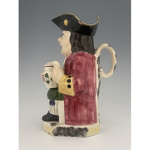 1002 - A Yorkshire Toby jug, circa 1800, modelled holding a frothing jug, pink coat and green breeches, 26.... 