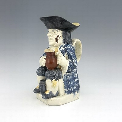 1013 - A Ralph Wood type Staffordshire Toby jug, circa 1770, modelled with frothing jug, barrel and resting... 