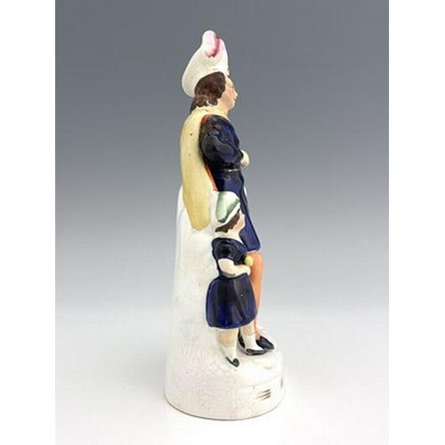 1021 - A Staffordshire figure of William Tell and his son, circa 1860, modelled as a flamboyantly dressed m... 