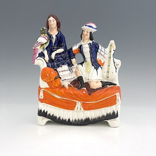 1026 - A Staffordshire figure of a seated man and woman on a chaise, circa 1870, female figure is modelled ... 