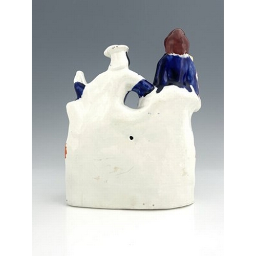 1026 - A Staffordshire figure of a seated man and woman on a chaise, circa 1870, female figure is modelled ... 