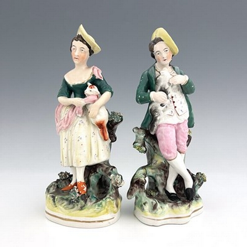 1031 - A pair of Staffordshire pastoral figures, circa 1870, standing female figure modelled with a brown a... 