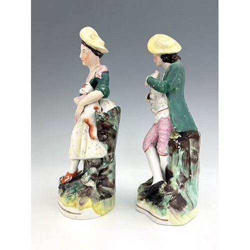 1031 - A pair of Staffordshire pastoral figures, circa 1870, standing female figure modelled with a brown a... 