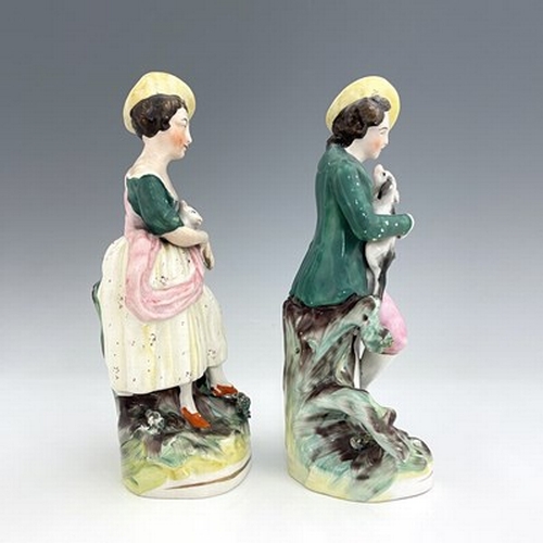 1031 - A pair of Staffordshire pastoral figures, circa 1870, standing female figure modelled with a brown a... 