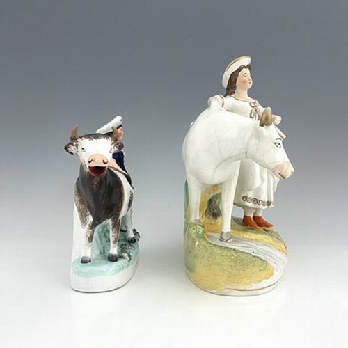 1035 - A Staffordshire cow and milkmaid figure, circa 1860, two similar groups, one predominantly white, he... 