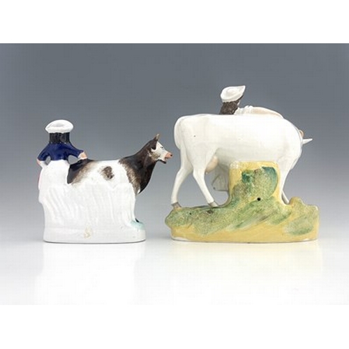 1035 - A Staffordshire cow and milkmaid figure, circa 1860, two similar groups, one predominantly white, he... 