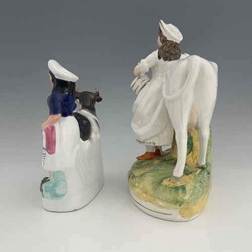 1035 - A Staffordshire cow and milkmaid figure, circa 1860, two similar groups, one predominantly white, he... 