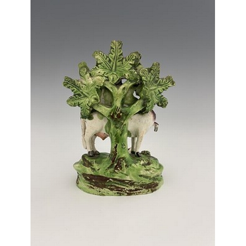 1042 - A Staffordshire boccage figure of a cow and calf, circa 1820, modelled in relief with applied rosett... 